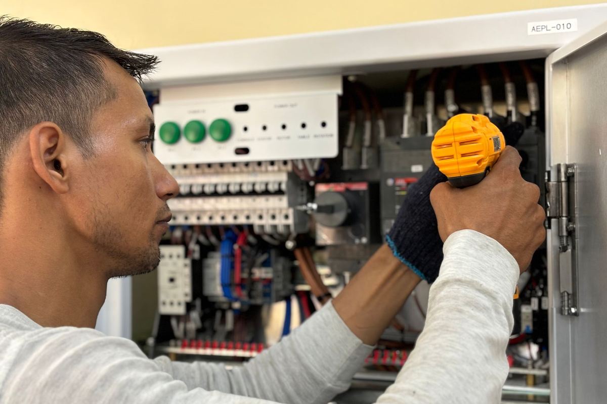 Eletricista fazendo manutenção em um quadro de energia